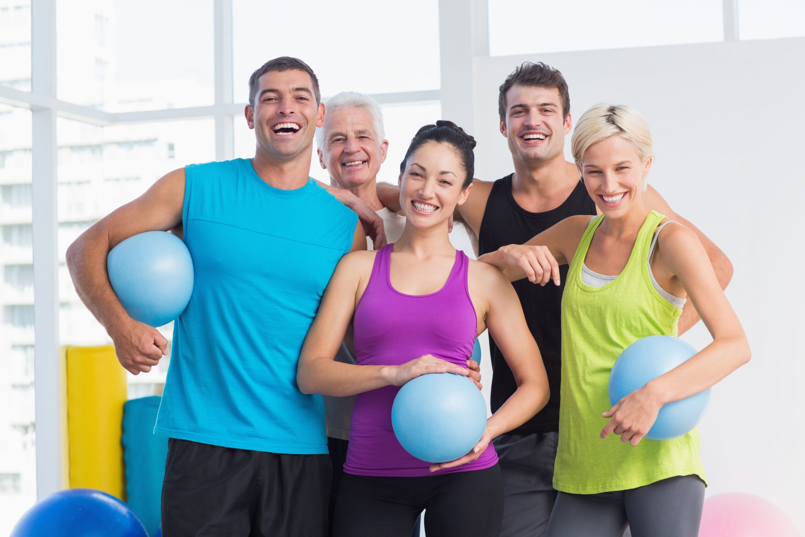 Portrait,Of,Cheerful,People,With,Medicine,Balls,In,Fitness,Studio